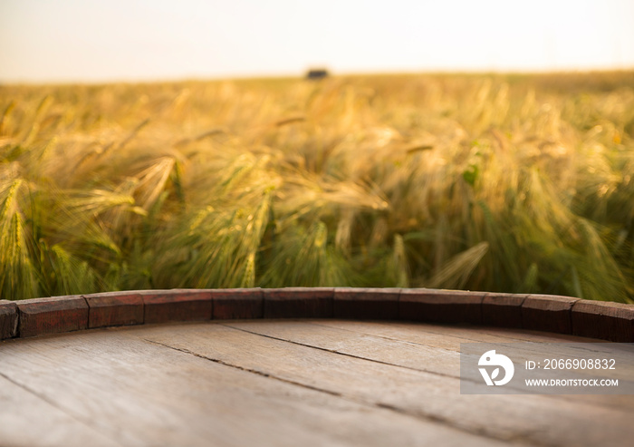 wooden board table in front of wheat field on sunset light. Ready for product display montages