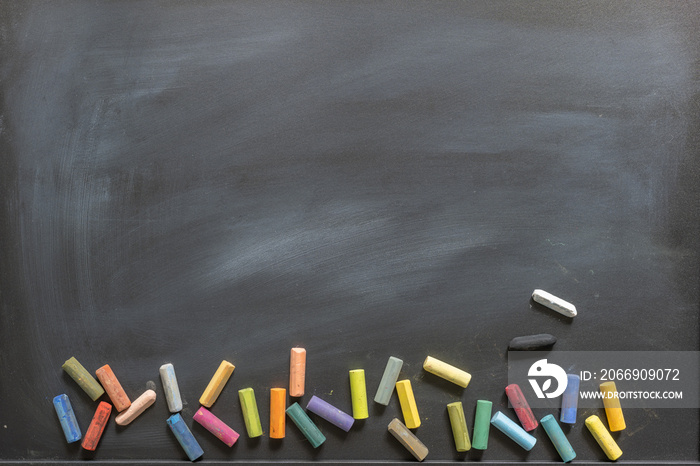 Blackboard with scattered chalks along the bottom