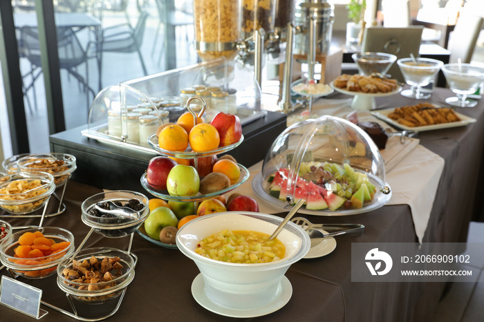 Healthy breakfast buffet table of fruit salad, various fruits, dried fruits, yoghurts during summer vacation in greek hotel.