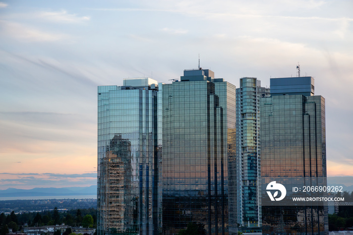 Aerial view of commercial and residential buildings during a vibrant summer sunset. Located near Metrotown Mall, Burnaby, Vancouver, BC, Canada.