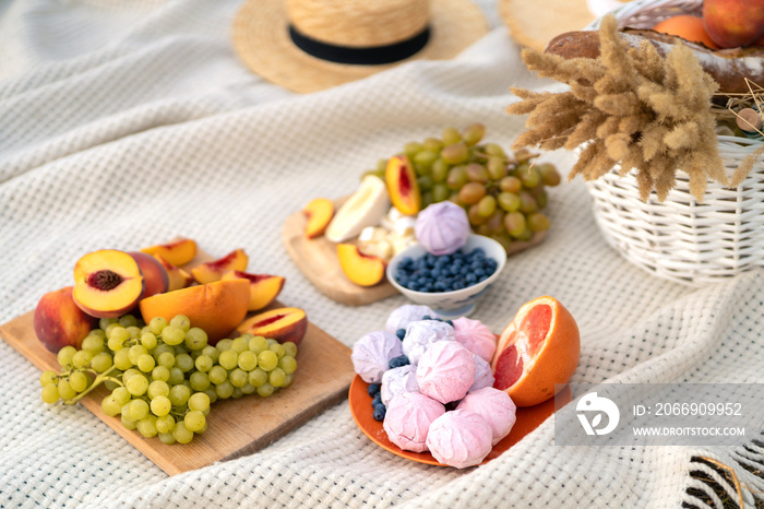 Stylish summer picnic on a white blanket.