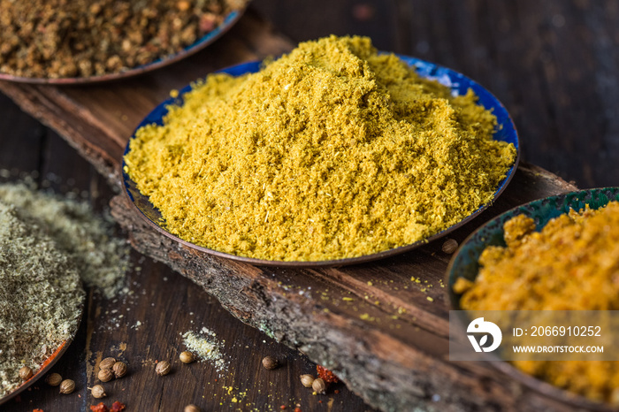 Heaps of various ground spices on wooden background. Georgian spices, Indian spices, Arabian spices. Spice variety. Herbs and spices