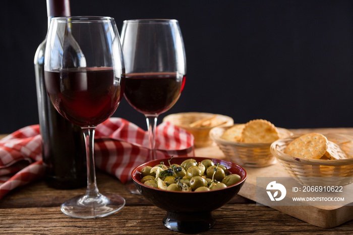 Close-up of marinated olives with glasses of wine