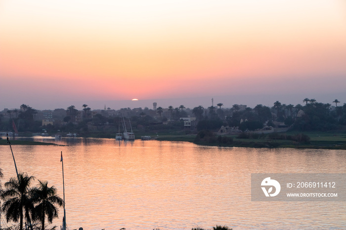 sunset with Nile river from Luxor, Egypt. orange sky reflected over the Nile river.