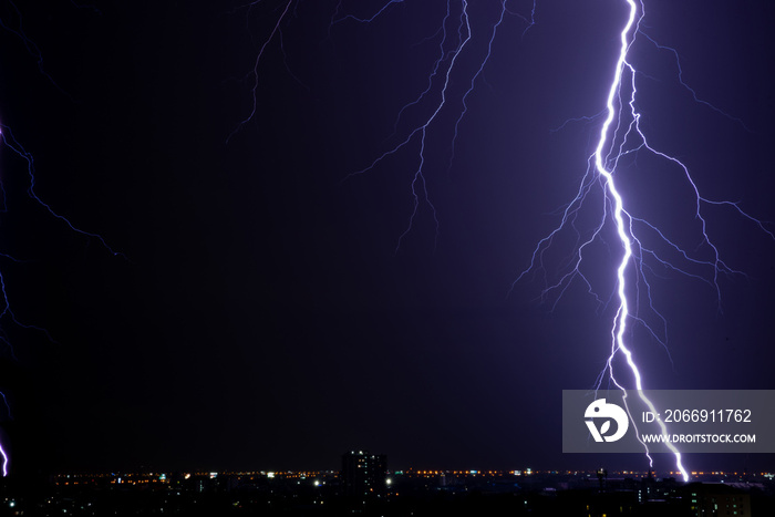 Thunderstorm lightnings from storm going to lightning rod on the roof building over night city