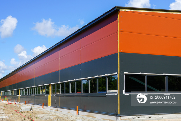 new metal frame factory building, covered with sandwich panels against a blue sky