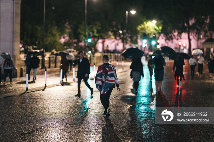 People mourn and bring flowers under the rain outside Buckingham Palace after Queen Elizabeth died