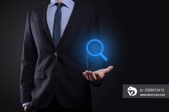 Businessman, man hold in hand magnifying glass icon.business, technology and internet concept