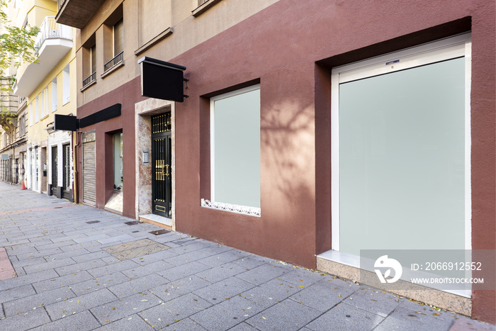 Shop fronts at street level with earth red painted walls and opaque glass surfaces