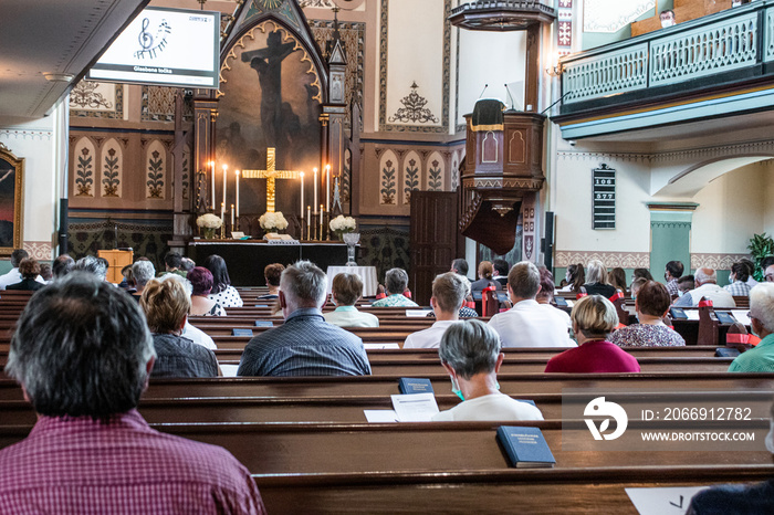 Holy mass in Christian church during the coronavirus pandemic Covid-19. Safe personal distance with protective masks