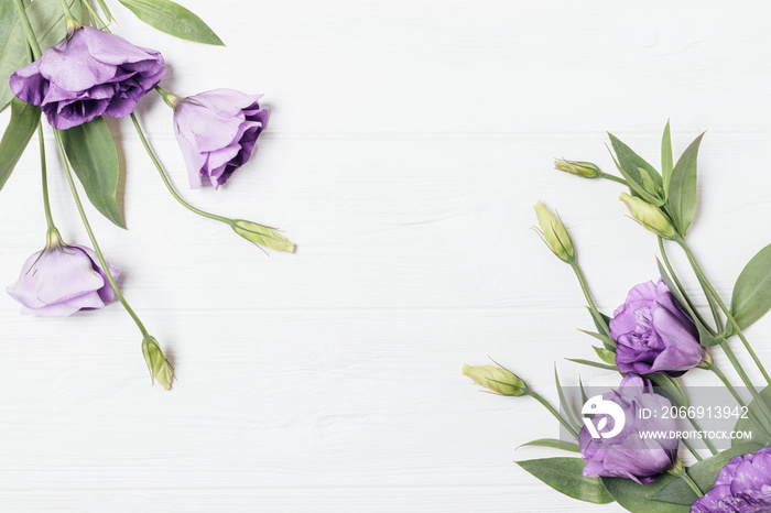 Flat lay frame of fresh flowers on white wooden table