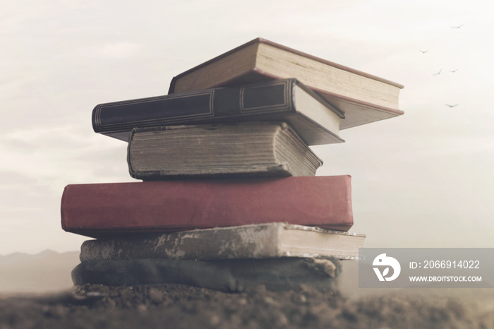 Surreal image of giant books on top of each other touching the sky