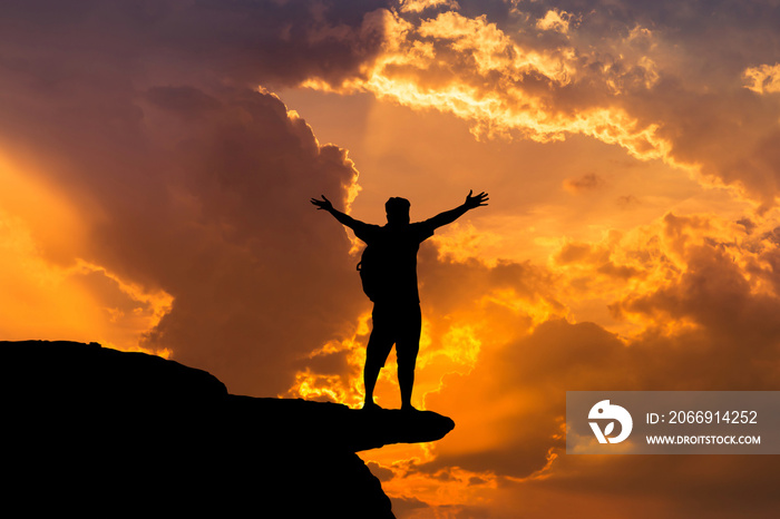 silhouette man backpacker standing raised up arms achievements successful and celebrate  on top mountain in sunset.