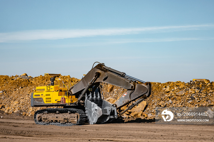 Yellow excavator steel bucket working on construction open mining site