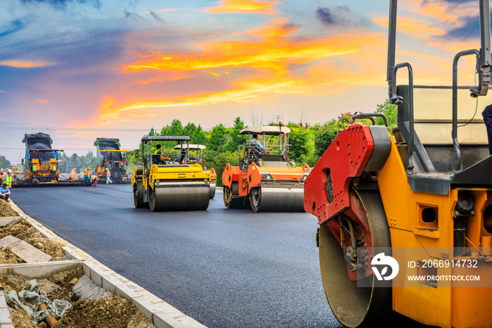 Construction site is laying new asphalt road pavement,road construction workers and road construction machinery scene.highway construction site landscape.