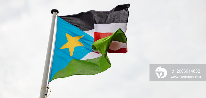 South Sudan flag waving against cloudy sky