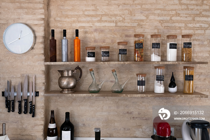 Kitchen bench shelves with various food ingredients on brick background