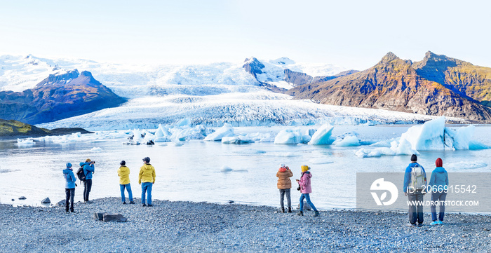 Icelandic landscape. Panorama of tourist visiting the Fjallsarlon glacier and the lagoon at sunset.