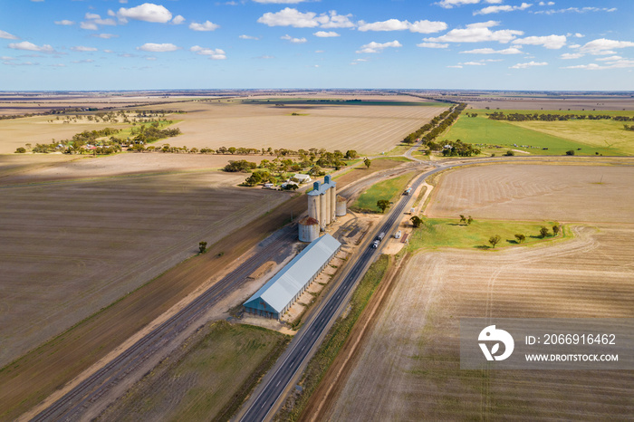 Looking down at the silos and country side in the Mallee on a cloudy day with shadows covering the land.