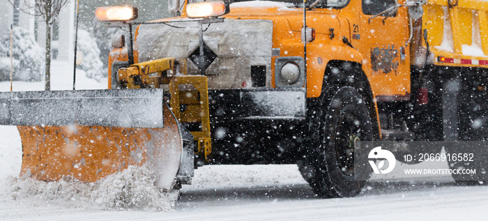 Close up of yellow blade of a yellow snowplow during a snow storm