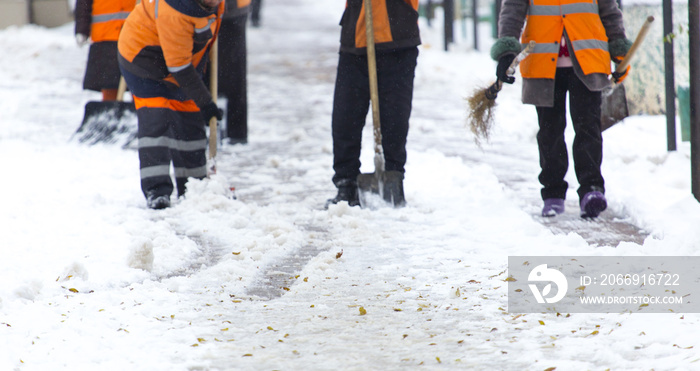 Employees of municipal services in a special form clear the snow from the sidewalk