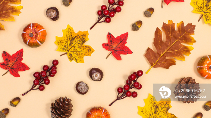 Autumn pattern with nuts and leaves on beige background. Creative fall background. Flat lay concept