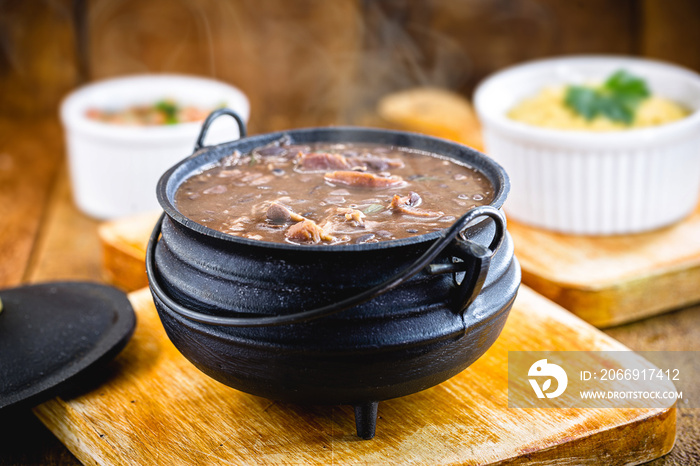 Brazilian Feijoada Food. Small, individual portion in an iron pan. small portion of feijoada, smoky and hot. Typical Brazilian food.