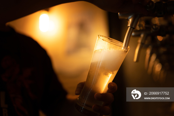 Bartender pouring larger beer in tap at restaurant and bar