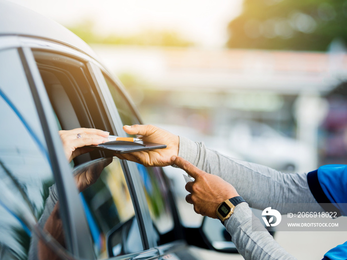 Selective focus to woman pay credit card with staff for fuel.