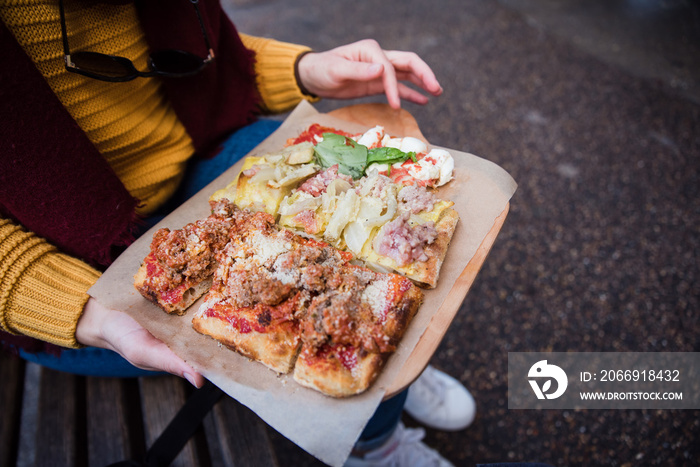 Top view of woman hand taking pizza