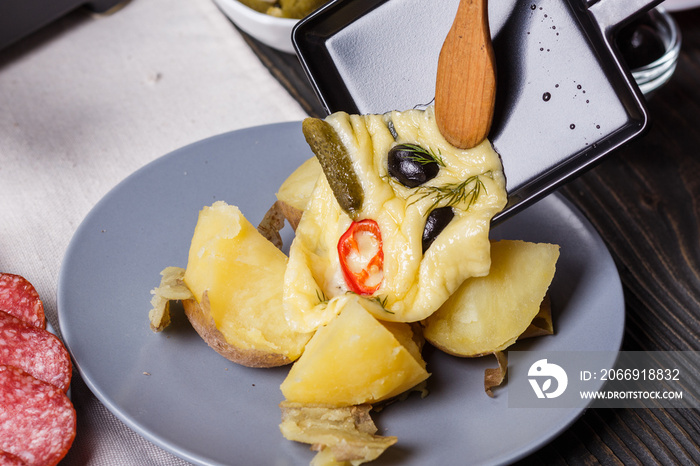 young woman is preparing a traditional Swiss cheese raclette