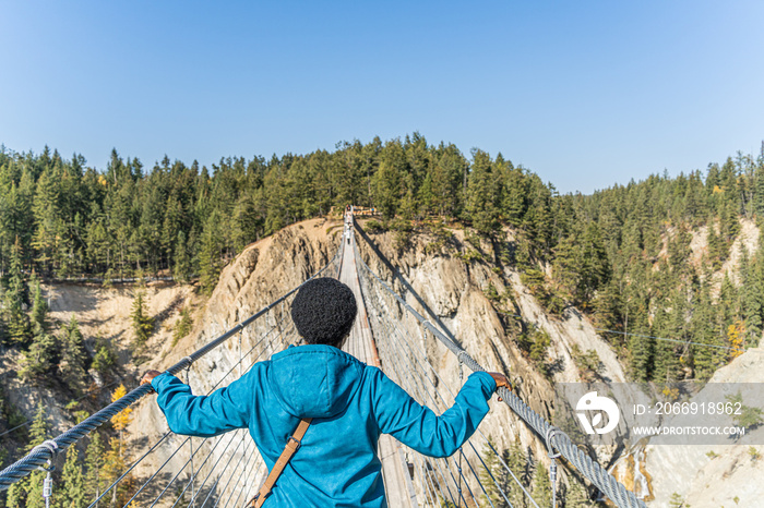 Woman crossing suspension bridge and conquering her fear