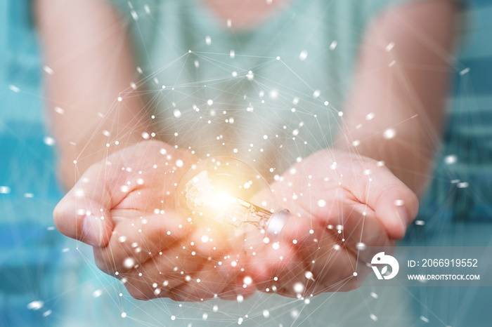 Businesswoman holding a lighbulb with connections in her hand