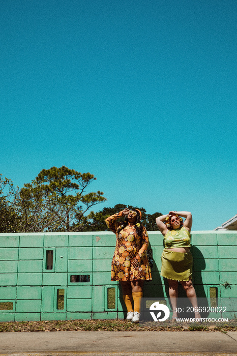 2 plus size women stand outside and look up