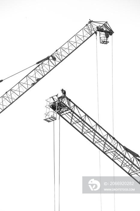 Black and white of Workers on a large construction crane on white background