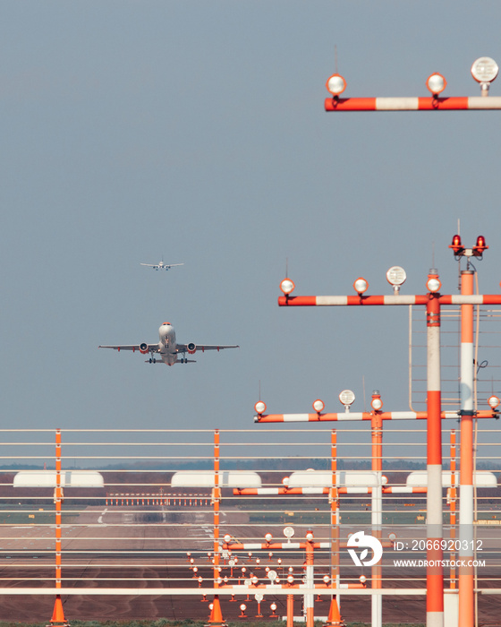 Düsseldorf Airport, Germany: Commercial passenger airplane during takeoff and landing. Landing lights and airport installations in the foreground.