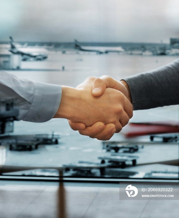 Business handshake on International Airport Terminal background