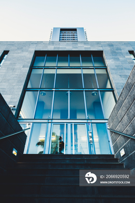 Main entrance door for commercial district like bank or insurance with people working inside - urban concept and modern town place - stairs and glass doors