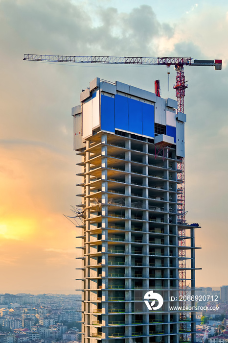 Construction crane at the top of a skyscraper building under construction