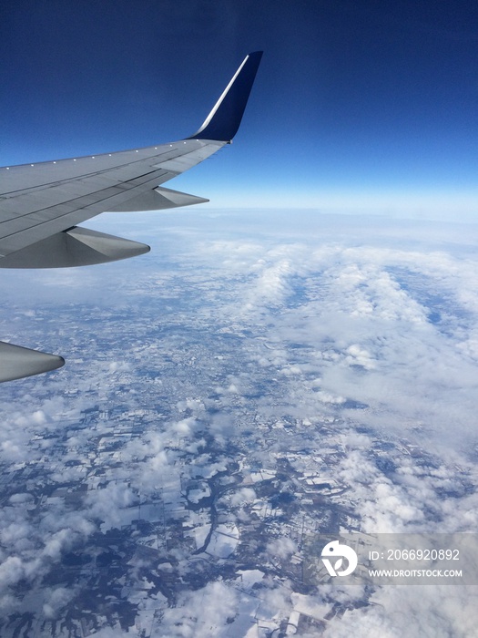 wing of an airplane flying above the clouds