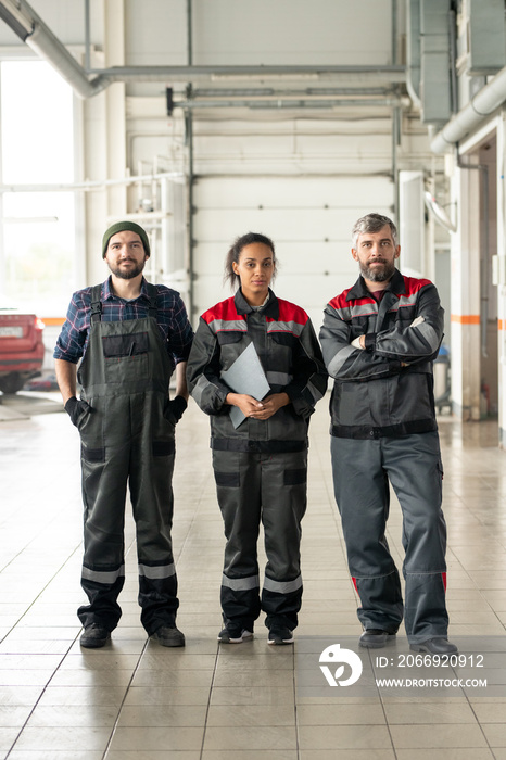 Three successful intercultural workers of contemporary car maintenance center