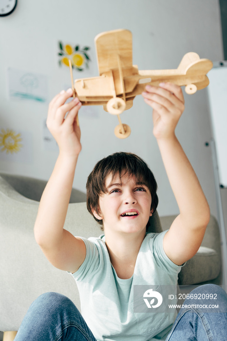 cute kid with dyslexia playing with wooden plane