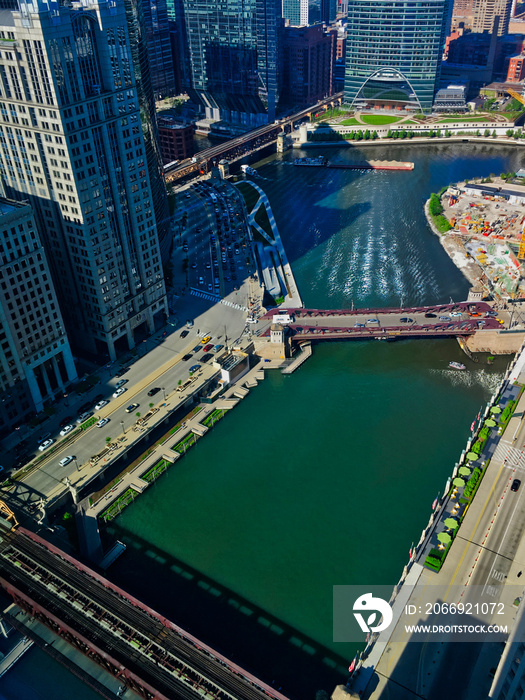 Patterns of light fan across the Chicago River as a barge crosses under Lake Street Bridge. Seen from above.