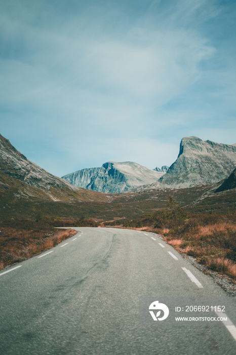 Empty road leading towards mountains on a moody autumn day in Norway.