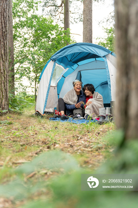 Mother and son using phone in tent