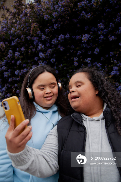 Two plus-sized women with Down Syndrome in workout clothes taking selfies