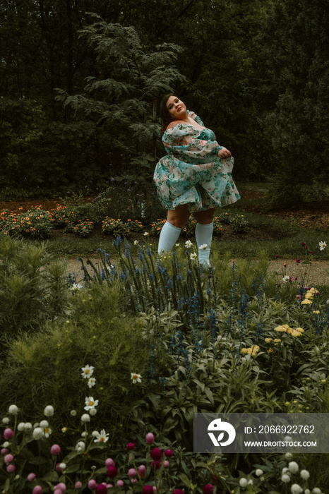 portrait of a plus size woman wearing a dress dancing in the garden