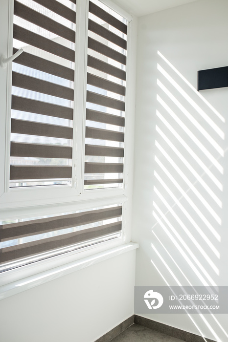 Roller blinds on balcony windows. Beautiful window blinds, sun protection