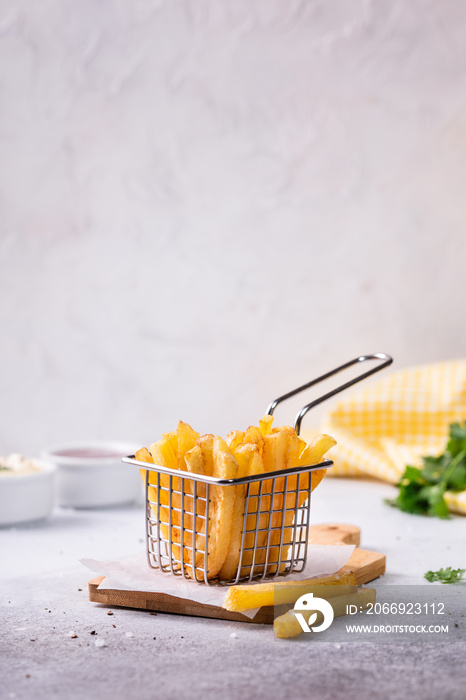 French fries in a basket on a modern white concrete background