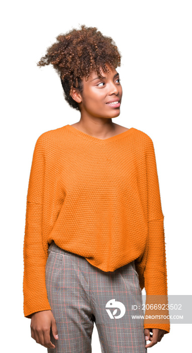 Beautiful young african american woman over isolated background looking away to side with smile on face, natural expression. Laughing confident.